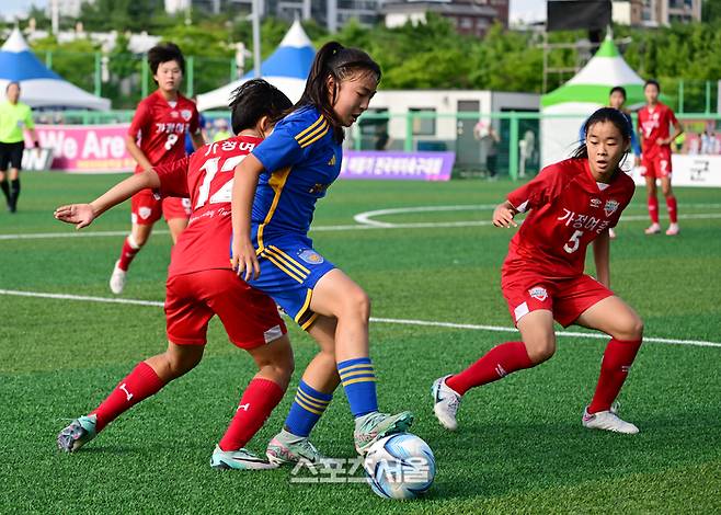 23일 경남 합천군 군민체육공원에서 진행된 ‘2024 스포츠 명품도시 웰니스 합천에서 펼쳐지는 제23회 여왕기 전국여자축구대회’ 중등부 현대청운중과 가정여중의 8강 경기에서 현대청운중 임지혜(가운데)가 가정여중 정연수(왼쪽)-정지윤 사이에서 드리블을 하고 있다. 2024. 6. 23.  합천 | 박진업 기자 upandup@sportsseoul.com