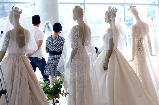 지난 2019년 서울에서 열린 한 웨딩박람회에서 예비 부부가 드레스 등 결혼 관련 상품을 둘러보고 있다. /뉴스1