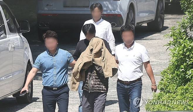 5월 12일 체포된 A씨가 경남경찰청으로 압송되고 있다. 연합뉴스