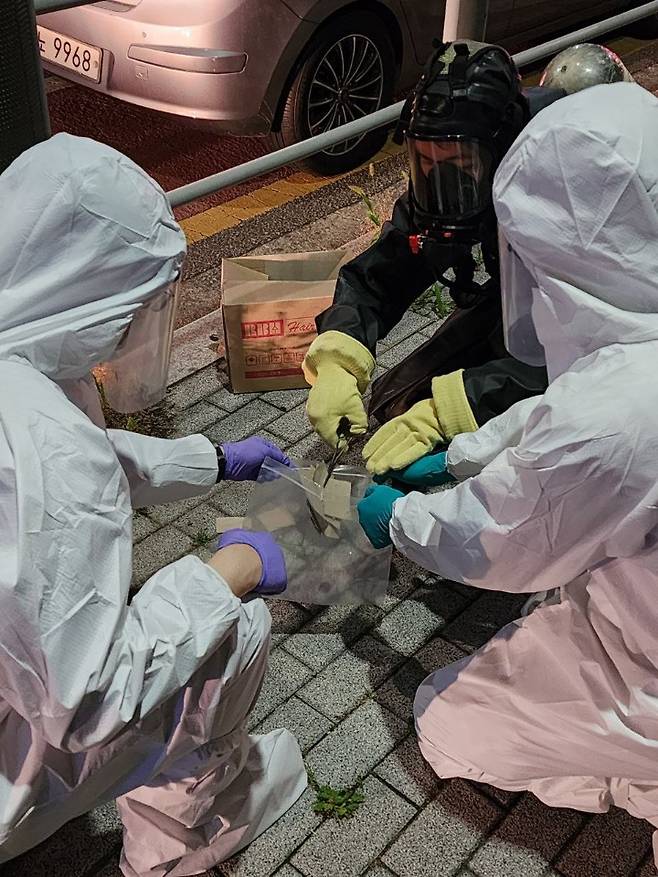 South Korean authorities in protective gear collect North Korean trash fallen on the streets in Seongbuk, a mid-north district in Seoul, on Tuesday. (South Korea’s Joint Chiefs of Staff)