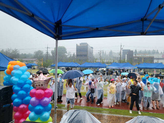 지난 22일 화성시 기배역사공원에서 열린 ‘기배동 한마음 체육큰잔치’에서 참여자들이 비를 맞으며 즐겁게 춤을 추고 있다. 기배동 체육진흥회 제공