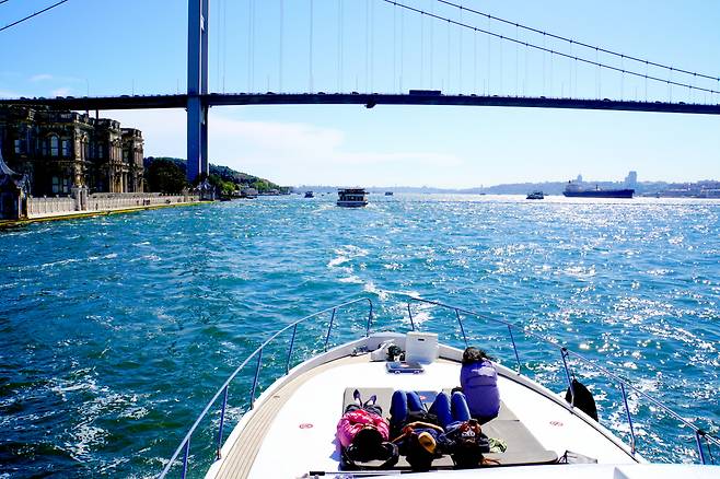 아시아와 유럽을 잇는 이스탄불의 다리를 보며 보스포러스 유람선 승객들이 동서 풍경을 즐기고 있다.