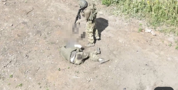 러시아 군인 한 명이 자신의 앞쪽에서 이동하던 전우가 우크라이나의 1인칭시점(FPV) 드론 공격에 부상을 당하자 구하는 대신 사살하기 위해 총구를 겨누고 있다. / 사진=데프몬 엑스