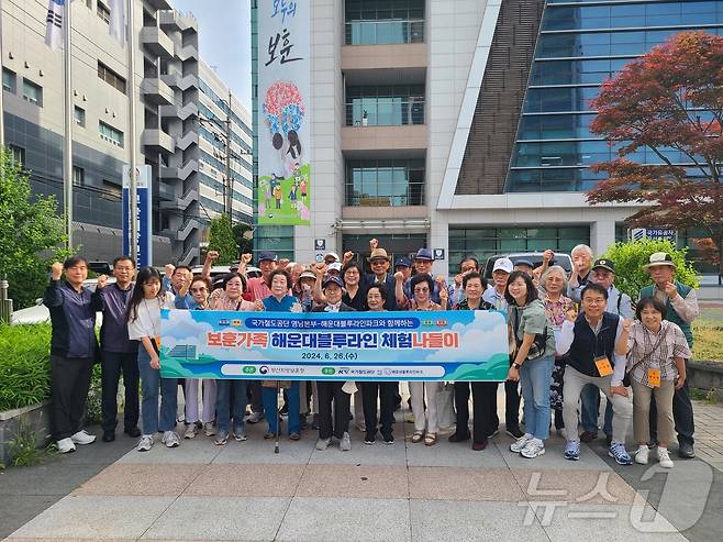 국가철도공단 관계자들과 국가유공자 가족들이 26일 부산지방보훈청 청사 앞에서 해운대 블루라인체험에 앞서 기념사진을 촬영하고 있다.(철도공단 제공) /뉴스1