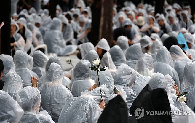 손에 쥔 추모의 꽃 [연합뉴스 자료사진]