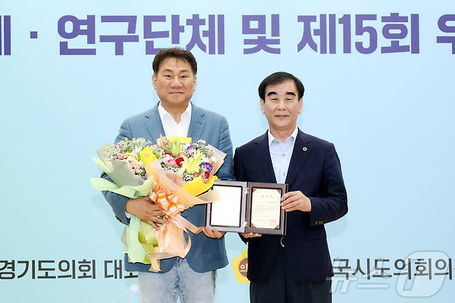 26일 경기도의회에서 열린 ‘2023년 우수연구단체 시상식’에서 최우수상을 받은 'DMZ생태평화관광연구회'의 회장 오준환 도의원(왼쪽)과 염종현 의장. (오준환 도의원 제공)