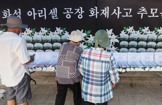 27일 경기도 안산시 단원구 다문화공원에 설치된 화성 아리셀 공장 화재 사고 추모 분향소에서 추모객이 희생자들을 추모하고 있다.  [연합뉴스]