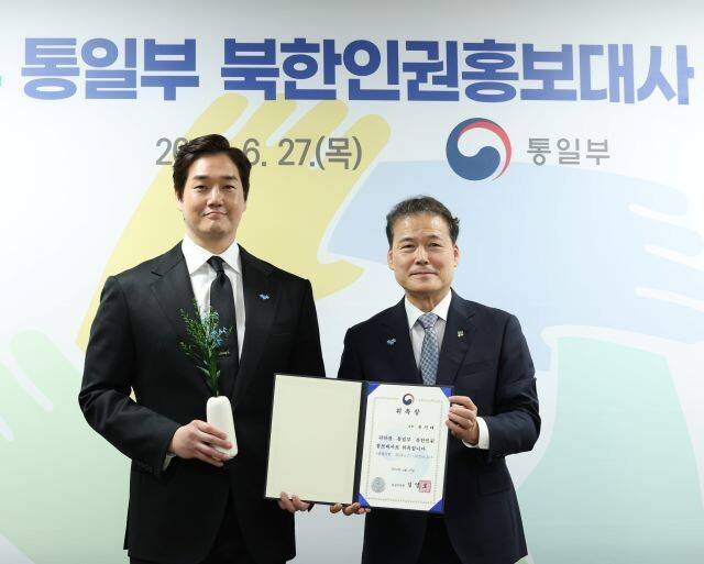 김영호 통일부 장관이 27일 서울 세종로 정부서울청사 통일부장관실에서 배우 유지태씨(왼쪽)를 ‘북한인권홍보대사’로 위촉한 뒤 함께 사진을 찍고 있다. 사진 통일부