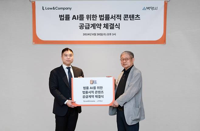 김본환(왼쪽) 로앤컴퍼니 대표와 안종만(오른쪽) 박영사 회장이 지난 26일 진행된 ‘법률 AI를 위한 법률서적 콘텐츠 공급계약 체결식’에서 기념 사진을 촬영하고 있다. [로앤컴퍼니 제공]