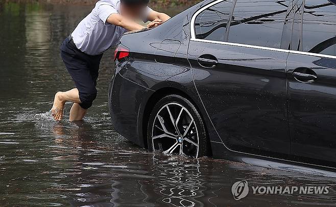 소나기에 침수된 도로, 차량 미는 시민 (포항=연합뉴스) 윤관식 기자 = 15일 경북 포항시 남구 괴동동 한 도로가 소나기로 침수된 가운데 한 시민이 침수된 차량을 밀고 있다. 2024.6.15 psik@yna.co.kr