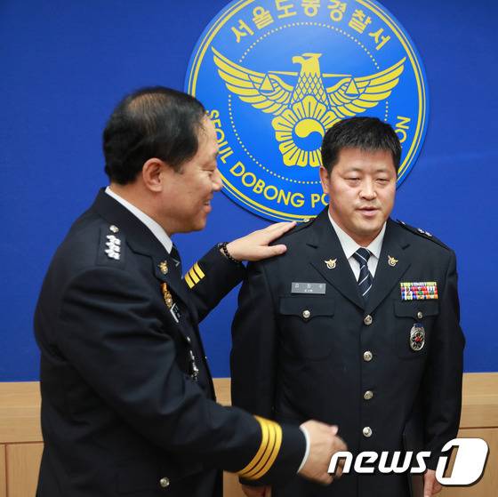 2016년 6월 30일 서울 도봉경찰서에서 여중생 집단 성폭행 사건 가해자 22명을 검거한 김장수 당시 경위(오른쪽)에게 이상원 당시 서울경찰청장이 1계급 특진 계급장을 달아주고 있다. (서울지방경찰청 제공) ⓒ News1