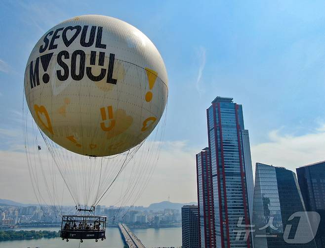 28일 서울 영등포구 여의도공원 상공에 보름달 모양의 열기구 '서울달'이 시험 비행을 하고 있다. 한강과 서울의 파노라마 야경을 동시에 즐길 수 있는 비행기구 ‘서울달’은 지난해 3월 발표한 ‘그레이트 한강 프로젝트’의 매력거점 조성사업이자 ‘서울관광 미래비전 3377 관광시대’ 실현을 위한 사업의 하나로, 시는 국내외 관광객이 즐겨찾는 핵심적인 서울 랜드마크가 될 것으로 기대하고 있다. 2024.6.28/뉴스1 ⓒ News1 김진환 기자