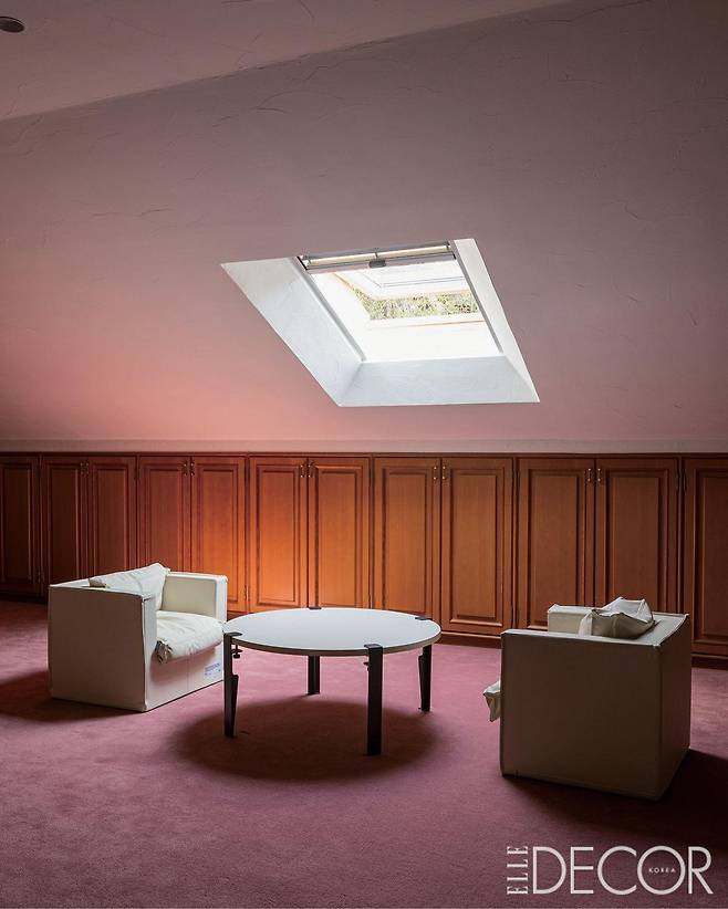 핑크빛 카펫이 깔린 다락 겸 2층 공간. 천창에서 내려오는 햇빛이 공간을 가득 채운다.