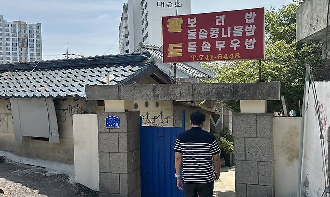 김효 논산시청 홍보실 주무관이 21일 낮 팔도식당 파란 대문을 들어서고 있다. 송인걸 기자