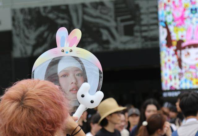 27일 일본 도쿄돔에서 열린 그룹 뉴진스 팬미팅 공연 '버니즈 캠프 2024 도쿄돔' 입장을 기다리던 관객들이 뉴진스 굿즈를 손에 들고 기념사진을 찍고 있다. 도쿄=연합뉴스