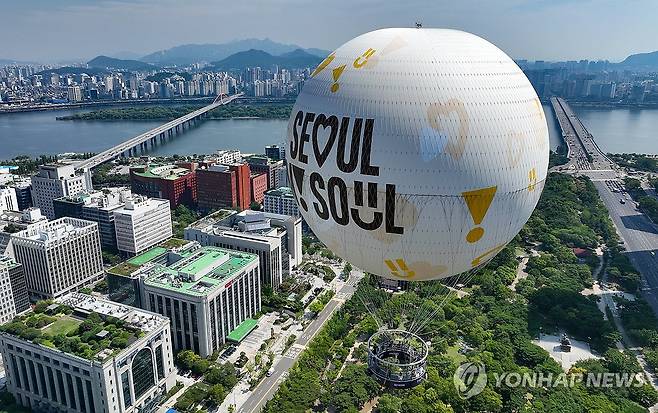 '서울달' 서울의 새 명물 (서울=연합뉴스) 김도훈 기자 = 28일 오전 서울 여의도공원에서 열린 계류식 가스기구 '서울달' 프레스투어 행사에서 취재진을 태운 '서울달'이 여의도 상공에 떠 있다.
    '서울달'은 7월 시범 운영을 거쳐 8월부터 시민과 관광객 대상으로 정식 운영된다. 2024.6.28 superdoo82@yna.co.kr