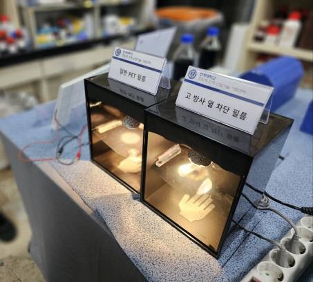 연세대 첨단과학기술연구관 '기능성 초미립자 공정연구실'에 설치된 장치. 각각 '일반 PET 필름'과 '고방사 열차단 필름'을 끼운 장치에 손을 넣으면 상자 윗 부분에서 열이 가해졌을 때 느껴지는 열감에 큰 차이가 난다. 고방사 열차단 필름은 적외선 파장대의 빛을 제어해 일종의 '냉장고 효과'를 낸다.