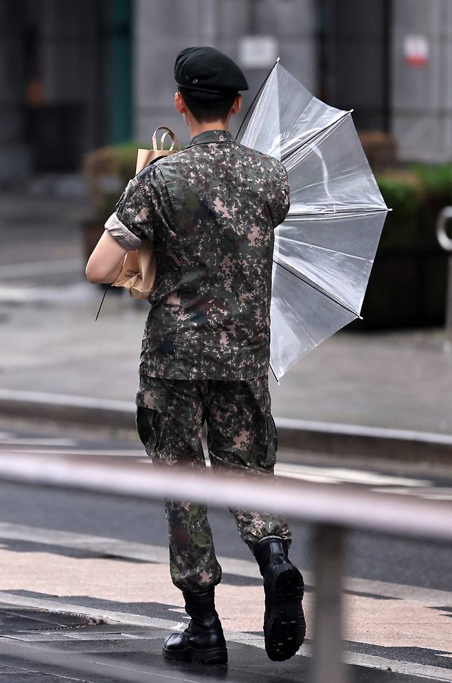 장마전선의 영향으로 전국이 흐린 가운데 30일 오전 서울 청계광장에서 군 장병이 바람에 망가진 우산을 접고 있다. /사진=뉴스1