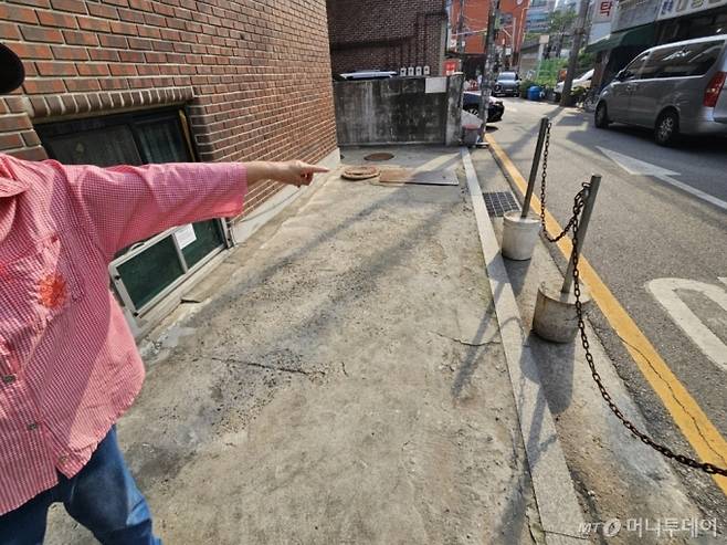 지난 27일 서울 관악구 신림동에서 반지하주택에 사는 주민 장씨가 하수구를 가르키며 설명하고 있다. 장씨는 "서울시에서 역류방지장치를 설치해줬지만 여전히 물막이판을 넘어오는 물보다 도로와 집안에서 역류하는 물이 더 무섭다"고 했다.  /사진=정세진 기자