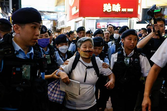 홍콩 경찰이 톈안먼 민주화 시위 35주년인 4일 홍콩 코즈웨이 베이 지역에서 경찰이 한 여성을 연행하고 있다. 연합뉴스