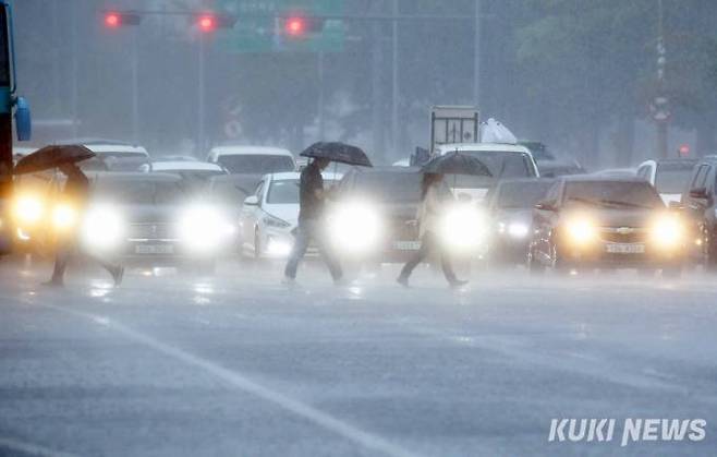 화요일인 2일 전국 대부분 지역에 돌풍과 함께 천둥·번개를 동반한 강하고 많은 장맛비가 내리고 있는 가운데 서울 여의도환승센터 횡단보도에 시민들이 우산을 들고 건너고 있다.