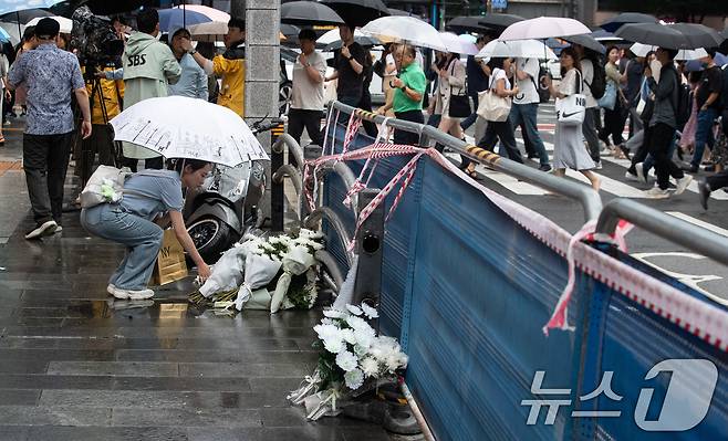 지난 밤 승용차가 인도로 돌진해 9명이 사망하는 사고가 발생한 가운데 2일 서울 중구 서울시청 인근 교차로 사고현장에서 퇴근길 한 시민이 헌화하고 있다. 2024.7.2/뉴스1 ⓒ News1 유승관 기자