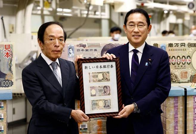 기시다 후미오 일본 총리(오른쪽)와 우에다 가즈오 일본은행 총재가 3일 일본 도쿄 일본은행 본점에서 새로 발행한 1만엔·5000엔·1000엔권 지폐를 소개하고 있다. [사진 제공=연합뉴스]