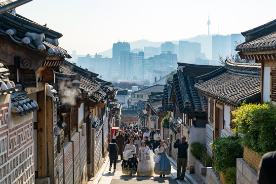Tourists wearing hanbok (traditional Korean dress) roam Bukchon Hanok Village in Jongno District, central Seoul, on Nov. 23, 2023. [JOONGANG ILBO]