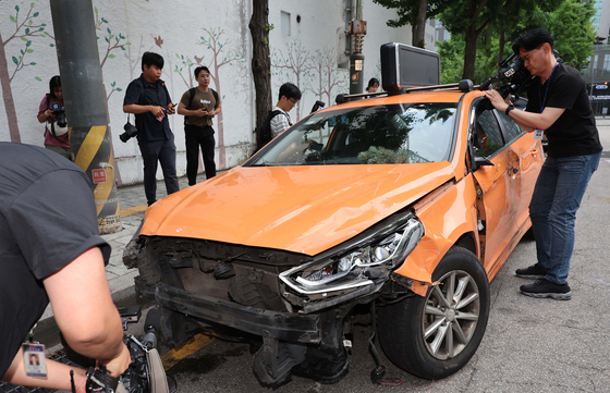 A taxi is battered after it crashed into a hospital in central Seoul on Wednesday, leaving three pedestrians injured. [YONHAP]