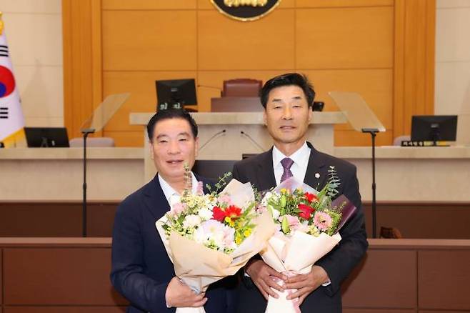 김일만 의장(오른쪽)과 이재진 부의장이 축하 꽃다발을 들고 기념촬영을 하고 있다. 시의회 제공