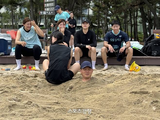 GS칼텍스 선수들이 3일 강원도 강릉 경포대 해수욕장에서 이영택 감독을 모래사장에 묻고 장난하고 있다. GS칼텍스 제공