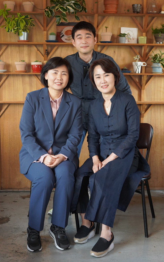 Director Kim Jung-in, center, and two of the mothers from the film ″A Long Way to School″ Lee Eun-ja, left, and Kim Nam-yeon, pose for photos after an interview with the Korea JoongAng Daily. [JEON TAE-GYU]