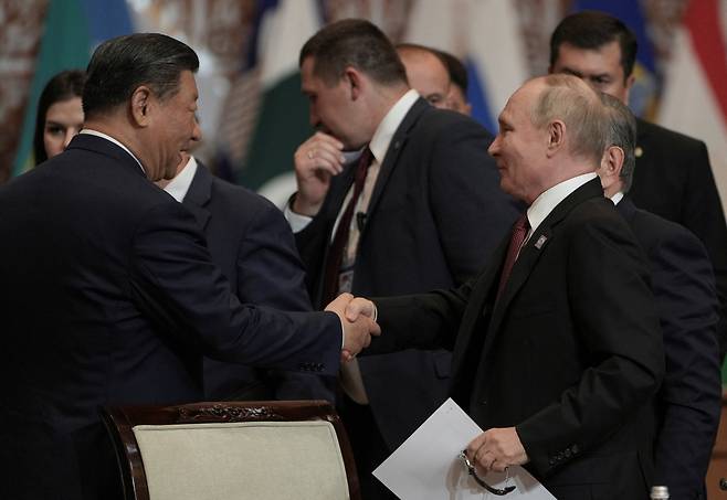 Russian President Vladimir Putin shakes hands with Chinese President Xi Jinping at Shanghai Cooperation Organization (SCO) summit in Astana, Kazakhstan, on Thursday. (Reuters)