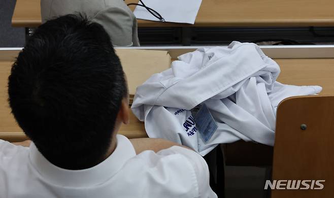 [서울=뉴시스] 김금보 기자 = 지난달 17일 서울시 종로구 서울대학교 의과대학 융합관 양윤선홀에서 열린 서울대학교 의과대학-서울대학교병원 교수협의회 비상대책위원회 주최 심포지엄에서 교수가 의사 가운을 벗어두고 안덕선 의료정책연구원장의 강연을 듣고 있는 모습. 2024.07.05. kgb@newsis.com