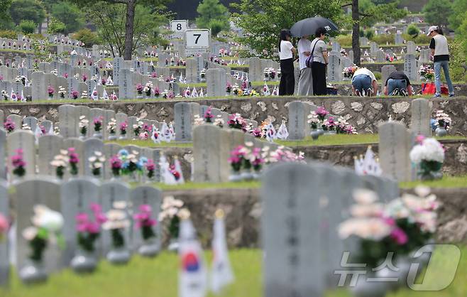 6.25전쟁 74주년을 하루 앞둔 24일 서울 동작구 국립서울현충원에서 유가족들이 고인의 묘역을 참배하고 있다. 2024.6.24/뉴스1 ⓒ News1 김도우 기자