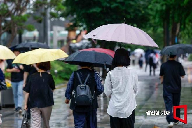 서울 여의도역 인근에서 시민들이 우산을 쓰고 이동하고 있다. 사진=강진형 기자aymsdream@