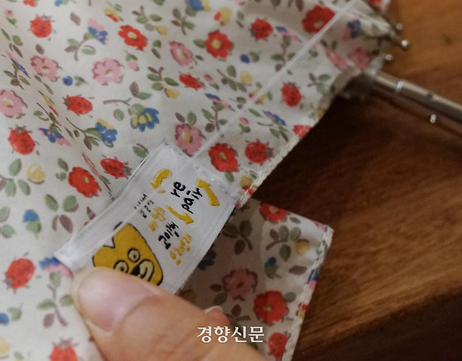 ‘살살접고 바짝 말려 고이 접어 오래오래’ 수리한 우산에 ‘리페어 우산’ 라벨을 부착하고 있는 활동가의 손. 우산은 관리만 잘 하면 얼마든지 수명을 늘려서 사용할 수 있다.