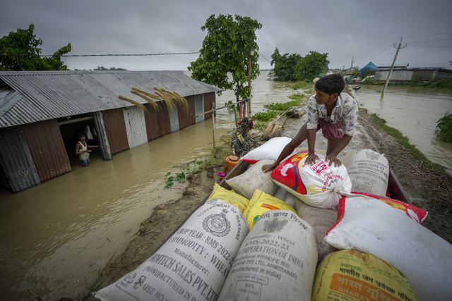 지난 2일(현지시각) 인도 아삼주 모리가온의 실두비 마을 주민들이 고지대로 옮길 쌀 포대를 차에 싣고 있다. 현지 당국은 인도 북동부에 지난 2주간 내린 폭우로 홍수와 산사태가 발생해 최소 52명이 숨졌다고 밝혔다. AP뉴시스