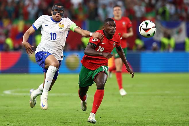 TOPSHOT - France's forward #10 Kylian Mbappe fights for the ball with Portugal's defender #19 Nuno Mendes during the UEFA Euro 2024 quarter-final football match between Portugal and France at the Volksparkstadion in Hamburg on July 5, 2024. (Photo by FRANCK FIFE / AFP)<저작권자(c) 연합뉴스, 무단 전재-재배포, AI 학습 및 활용 금지>