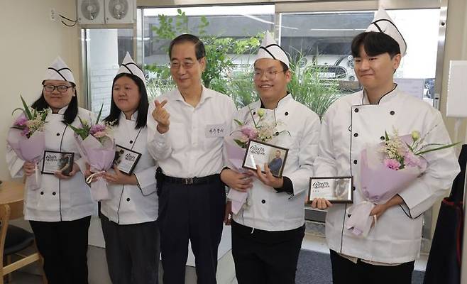 한덕수 국무총리가 7일 오전 경계선 지능 청년 상생 일터인 서울 종로구 청년밥상문간 슬로우점을 찾아 경계성 지능 청년 직원과 함께 기념촬영을 하고 있다. (공동취재) ⓒ뉴시스