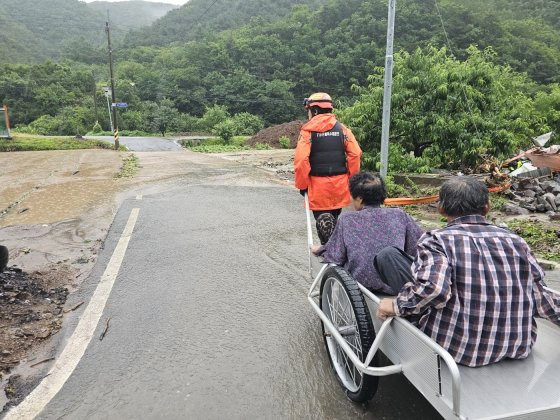 8일 오전 경북 안동시 임동면 대곡리 한 마을이 집중호우로 침수된 가운데 소방 관계자가 침수된 마을에서 주민을 구조하고 있다. 사진 경북소방본부