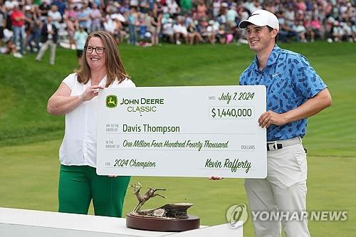 우승 상금 수표 모형을 받고 기뻐하는 톰프슨. [AFP/게티이미지=연합뉴스]