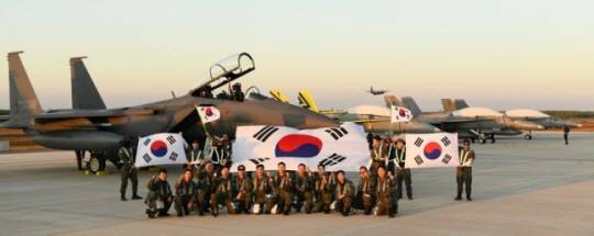 공군의 F-15K전투기 조종사들이 10일 오후 다국적 연합공중훈련 ‘2024 피치블랙’이 실시될 호주 다윈기지에 도착해 한국 공군 F-15K와 말레이시아 공군 F-18을 배경으로 기념촬영하고 있다. 공군 제공