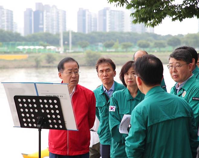 홍준표 대구시장이 11일 오후 4시 집중호우로 침수 피해를 입은 동구 동촌유원지 일대를 방문, 관계자들로부터 침수 피해 현황 및 복구 방안 등에 대해 설명을 듣고 있다. 대구시 제공