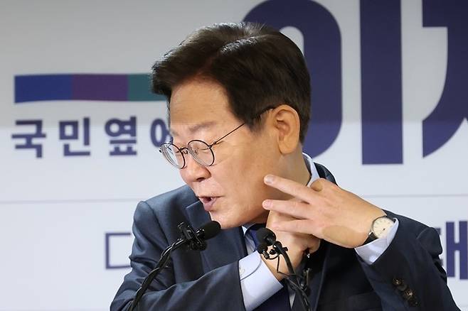 이재명 전 더불어민주당 대표가 지난 10일 오전 서울 여의도 중앙당사에서 열린 8·18 전당대회 당 대표 출마 선언 기자회견에서 질의응답 도중 태극기 배지를 거꾸로 달았다는 한 기자의 지적에 고쳐 달고 있다. 뉴시스