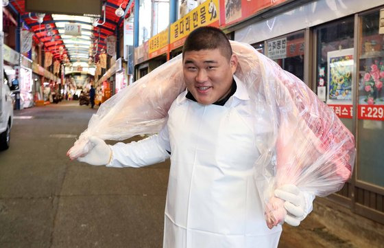 부친이 운영하는 서울 마장동 육가공 가게에서 도축된 돼지를 들쳐 메고 옮기는 김민종. 중앙포토