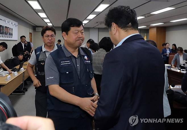 류기섭 한국노총 사무총장과 인사하는 이인재 최저임금위원장 (세종=연합뉴스) 배재만 기자 = 이인재 최저임금위원장이 12일 새벽 정부세종청사에서 열린 제11차 전원회의에서 노사 양측 최종안의 표결을 거쳐 내년 최저임금이 시간당 1만30원으로 결정된 뒤 류기섭 한국노총 사무총장과 악수하고 있다. 2024.7.12 scoop@yna.co.kr