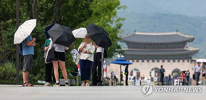 '서울 더워요' (서울=연합뉴스) 서대연 기자 = 서울 한낮 기온이 30도까지 오른 11일 오후 서울 종로구 광화문 광장에서 양산을 쓴 관광객들이 이동하고 있다. 2024.7.11 dwise@yna.co.kr