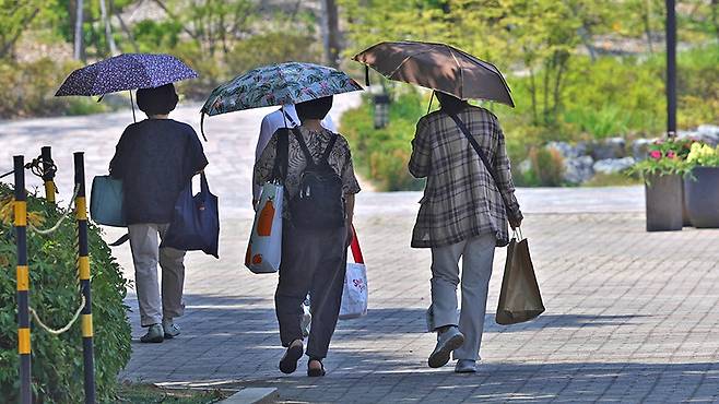 '양산으로도 모자라' (고양=연합뉴스) 임병식 기자 = 수도권에 폭염주의보가 내린 지난 6월 19일 경기도 고양시에서 양산을 쓴 시민들이 그늘 밑으로 이동하고 있다.