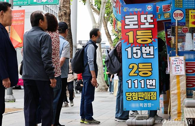 서울 시내의 한 복권방에서 복권을 사려는 시민들로 붐비고 있다./사진=[서울=뉴시스] 김근수 기자